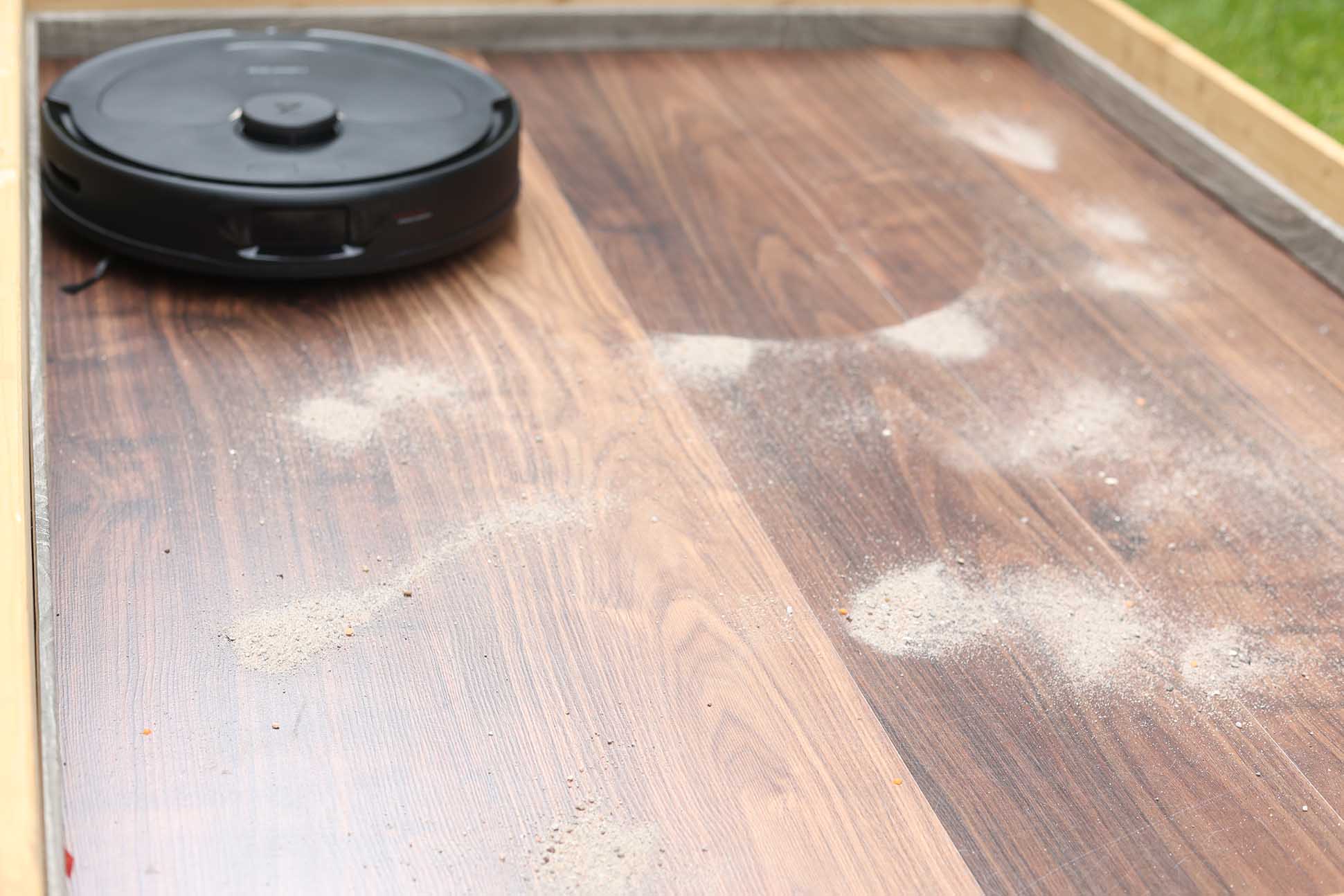 Roborock Q Revo beim Sand-Saugtest auf dem Laminat.